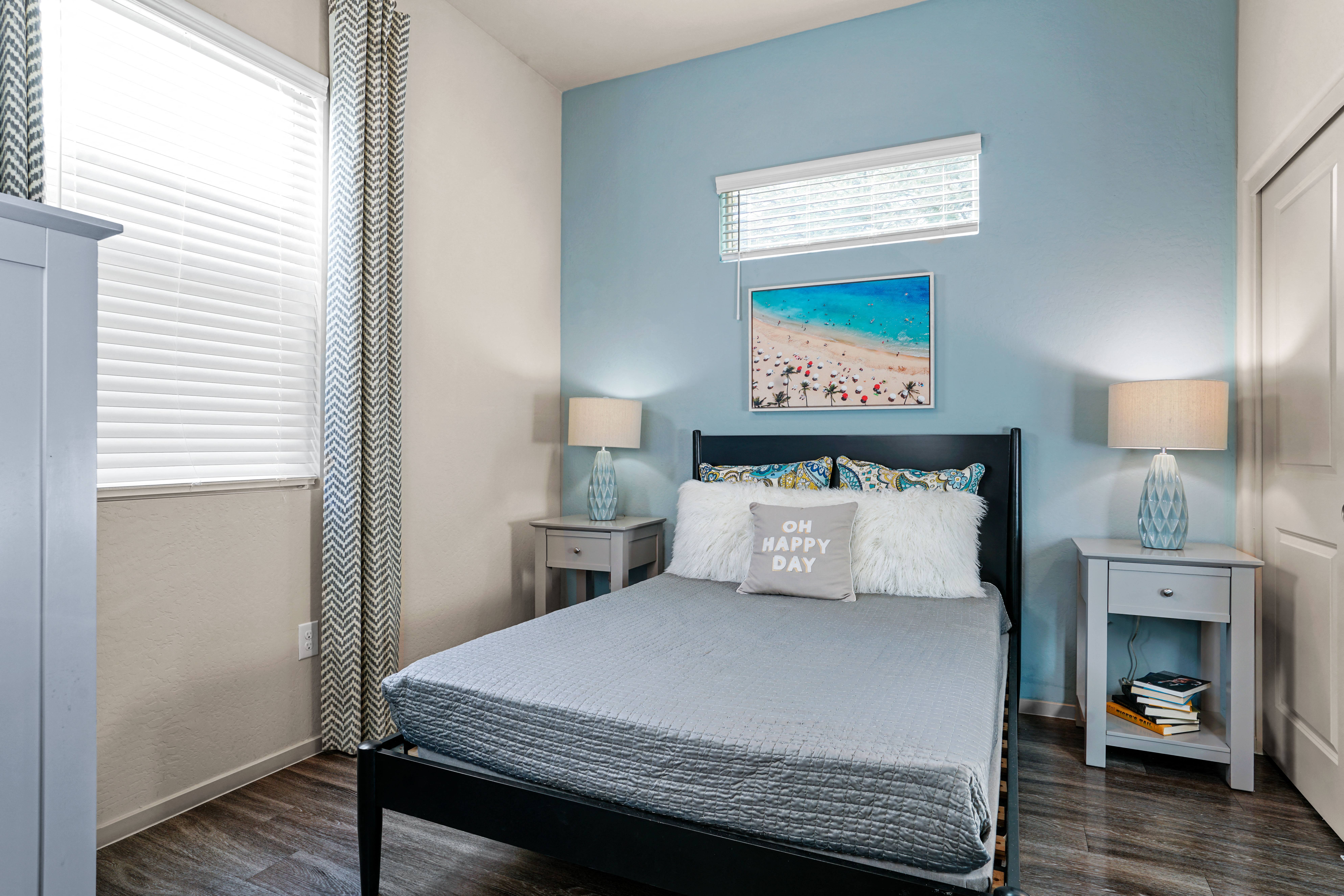 a bedroom with a bed and two nightstands and a window at Olive Queen Creek Apartments, Queen Creek, AZ
